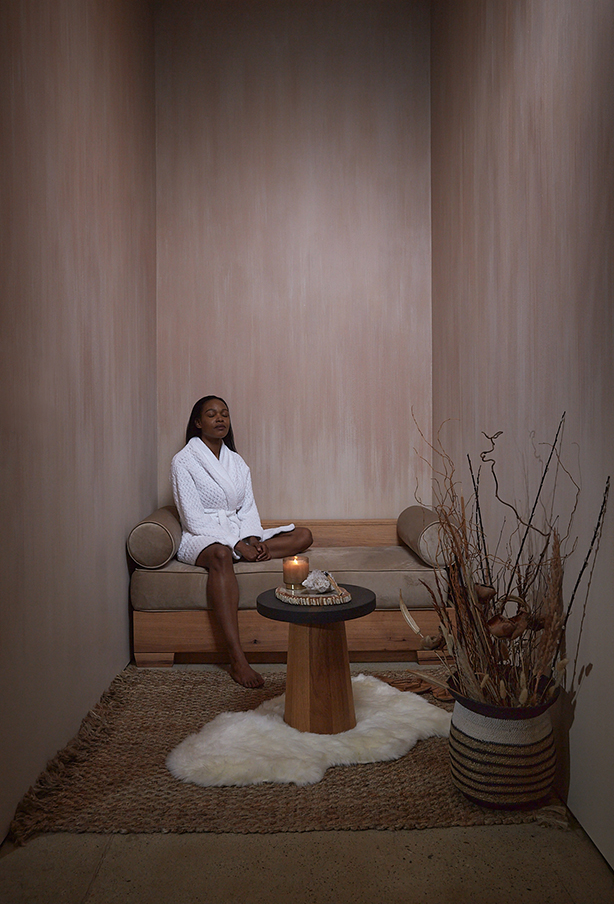 Guest in white robe seated in the PALOMA nook, at rest between services