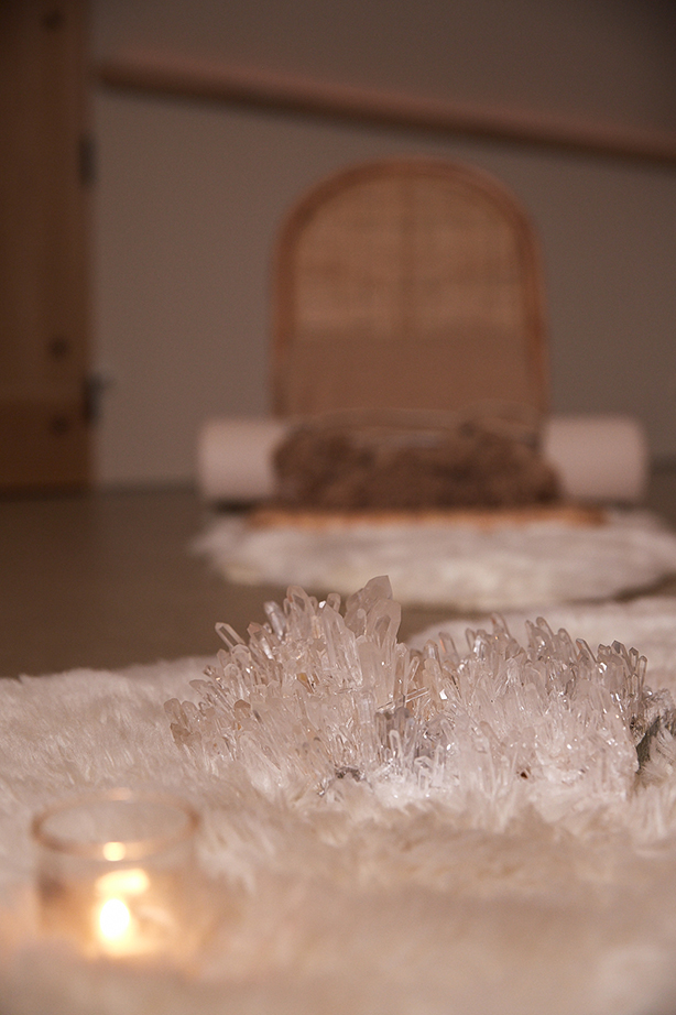 The PALOMA Meditation Dome set for a ceremony — crystal clusters on white fur, candles, arched rattan chair in the background