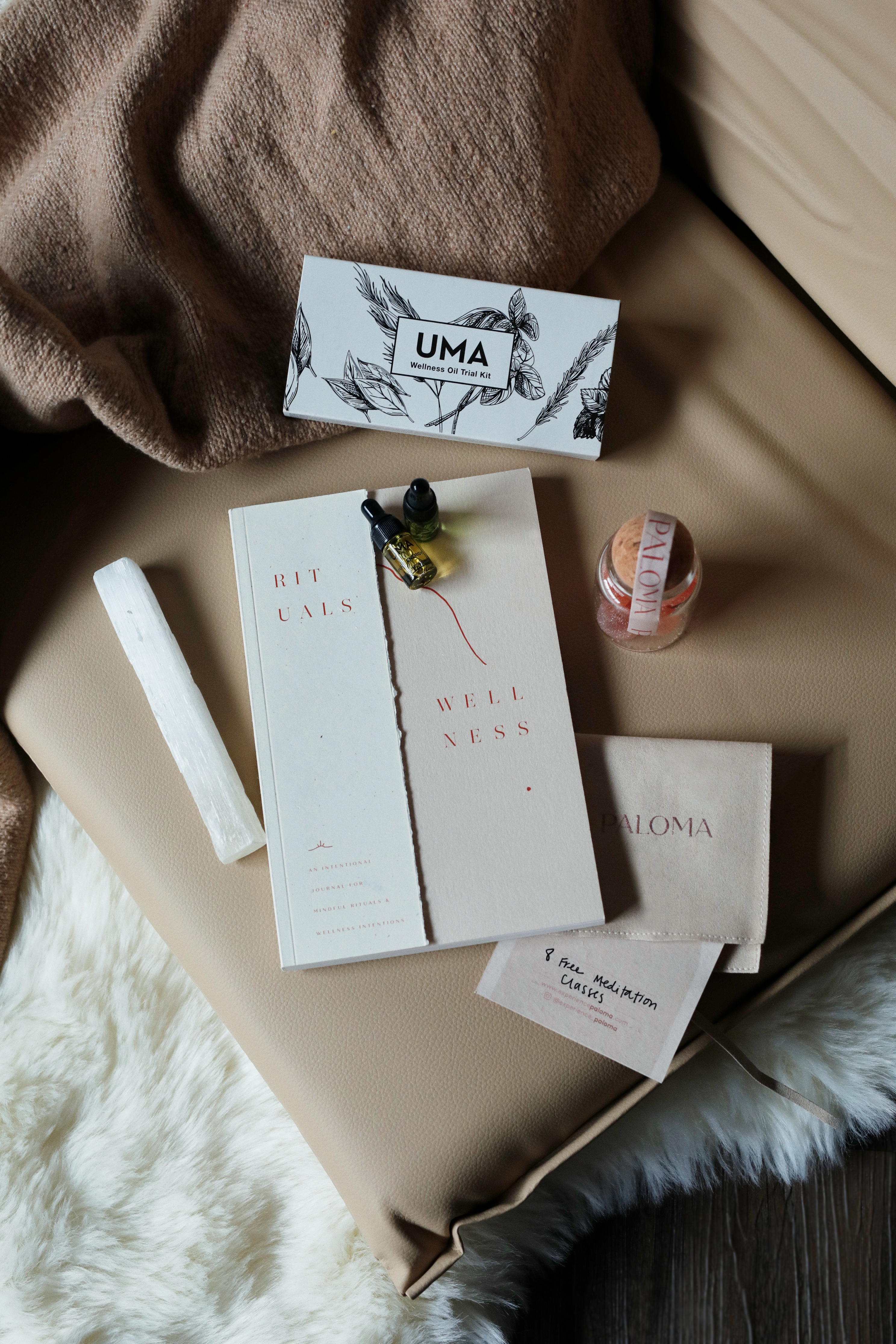 PALOMA event gift kit flat lay — journal, selenite wand, gummies, and branded cards