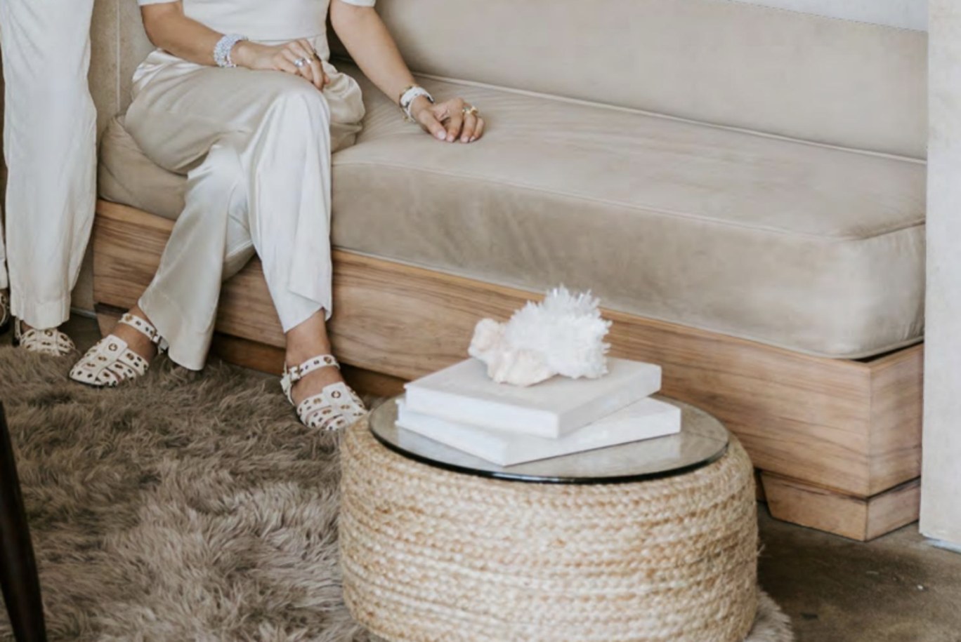 A quartz cluster resting on stacked books beside the linen bench.