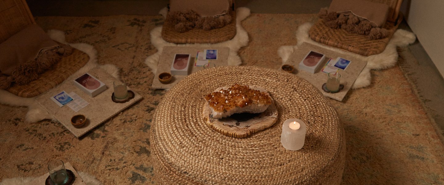 The Dome set for a circle: two rattan chairs, sheepskins, cards and a candle on the rug.