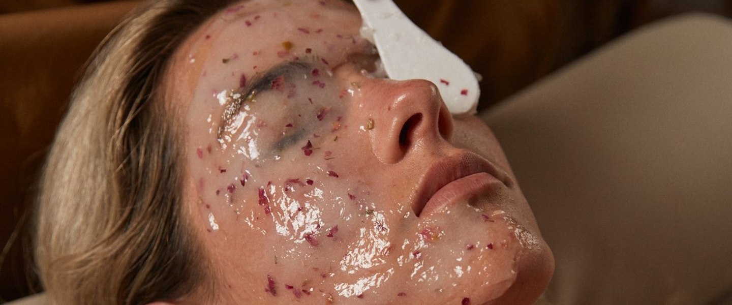 A facial treatment in progress, product being applied with a flat brush.